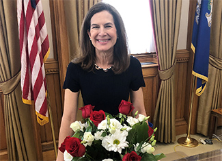 Susan Bysiewicz poses with flags and flowers
